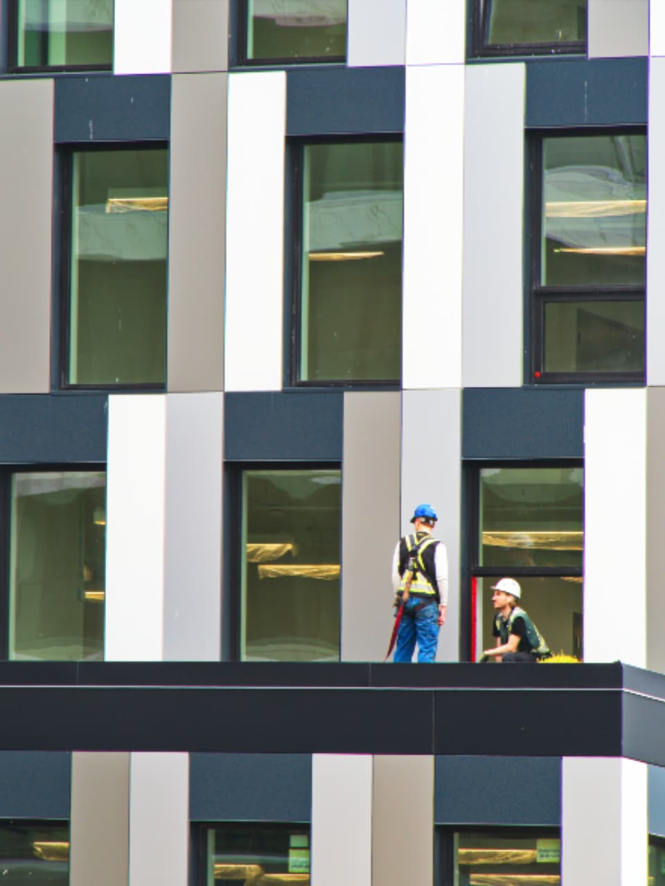 Construction workers in hard hats on a building under construction.
