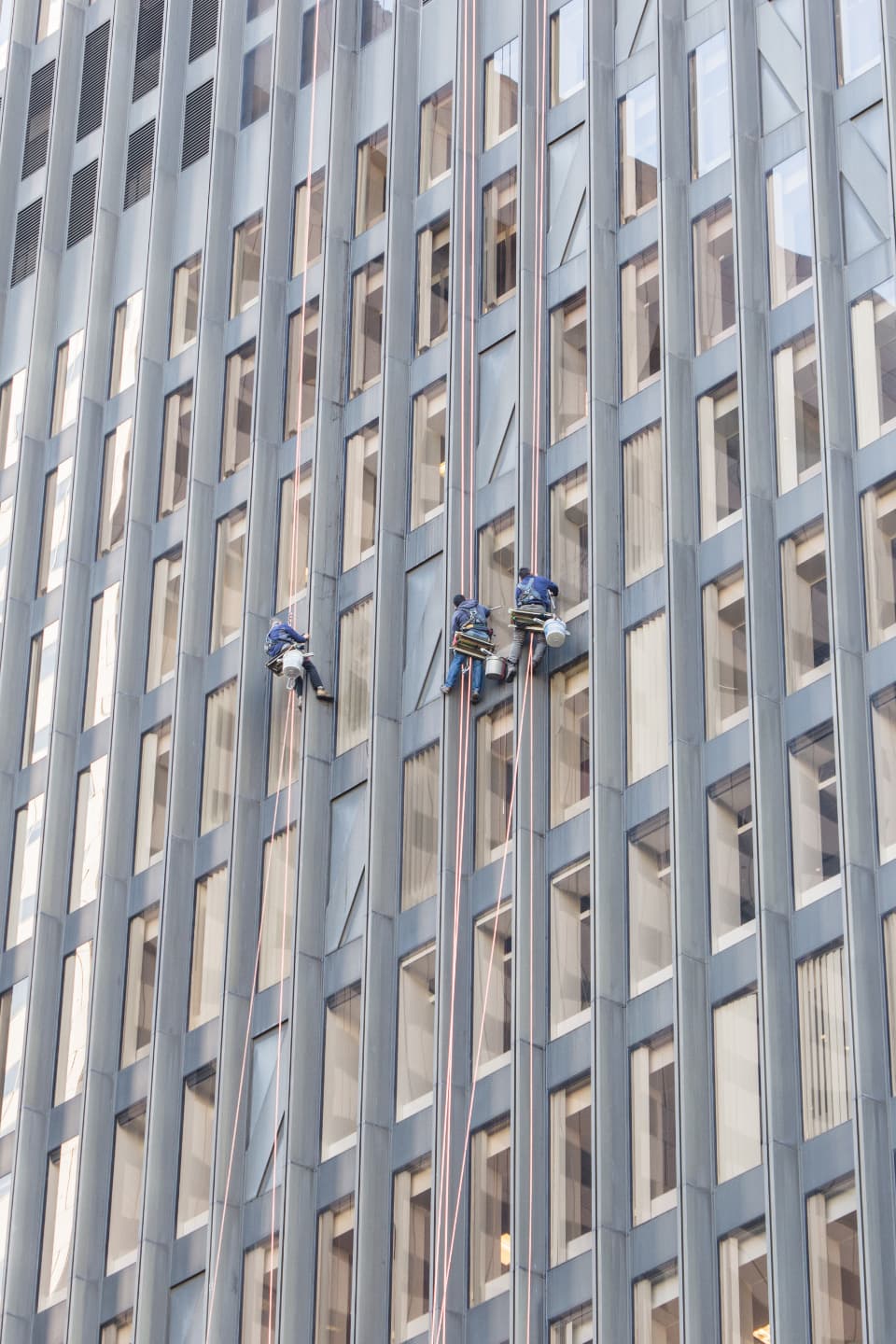 Maintenance workers on the face of an office building.