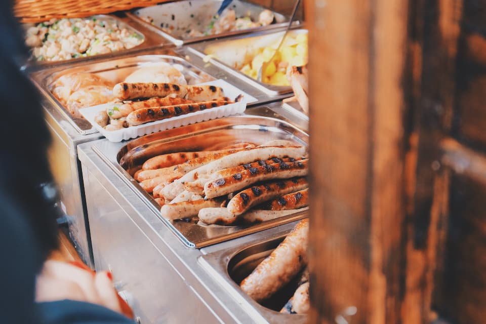 A catered buffet line with hot trays of food.